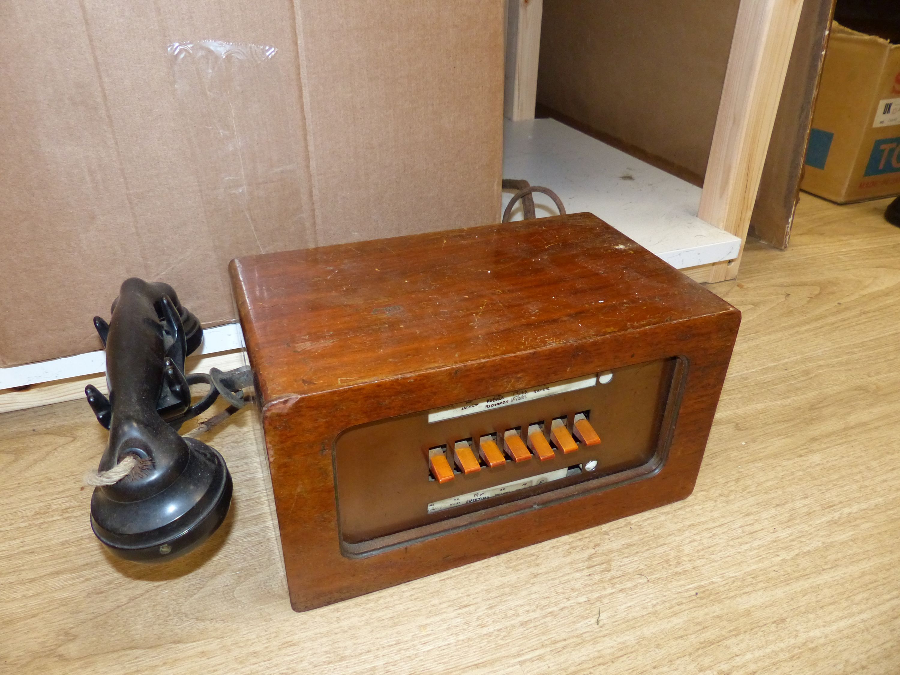 A vintage walnut-cased telephone switchboard with black Bakelite handset